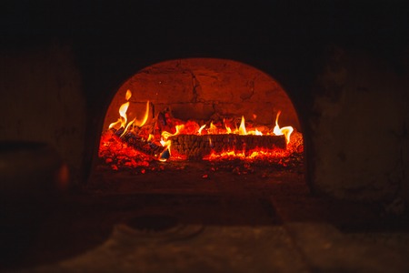 Hot coal in a Russian stove in the dark burning with red fire.の写真素材