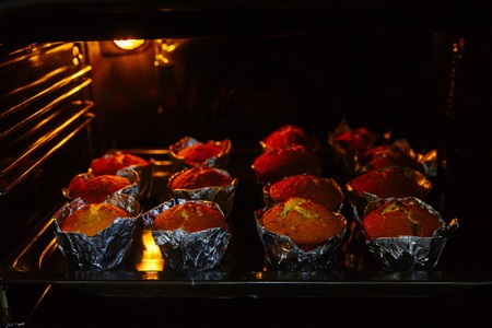 Cooking cupcakes at home. Baking on a baking sheet in the oven.の写真素材