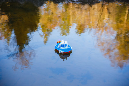 Toy ship sailing in the river at sunset.