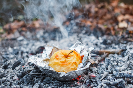 Apple baked on coals in the evening.の写真素材