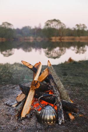 Kettle stands by the fire on the lake.の写真素材