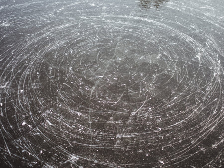 Ice texture with marks from the blades of the skates in a circle.