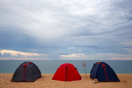 Three tents by the sea at sunset day. Background of the evening sky for an inscription.の写真素材