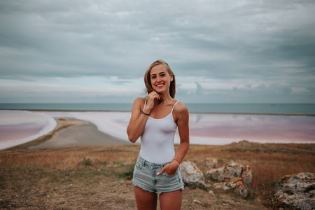 Portrait of a beautiful girl in a white bodysuit in pink salt lakes.の写真素材