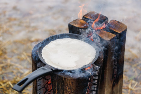 Cooking pancakes in a frying pan on a burning Finnish candle.の写真素材