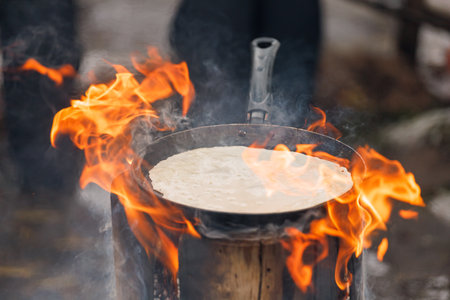 Cooking pancakes in a frying pan on a burning Finnish candle.の写真素材