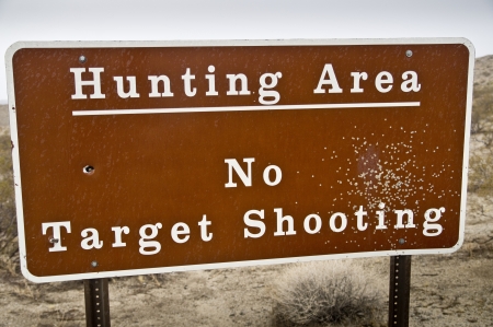 A sign blasted by a shotgun warns hunters that they must shoot to kill - no more practicingの写真素材