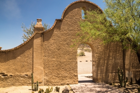 An arched wall and entry to Mission San Xavier shows the distinctice Spanish colonial influence of the architecture の写真素材