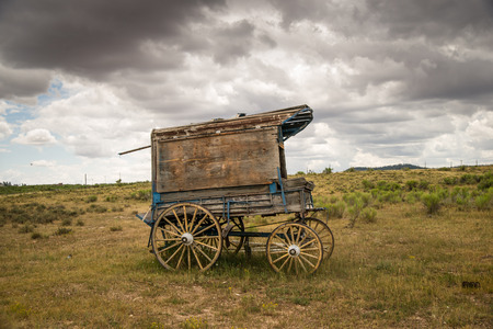 An old west sheriff's wagon sits on the lonesome frontier prarie as storm clouds gather in the distance.の写真素材