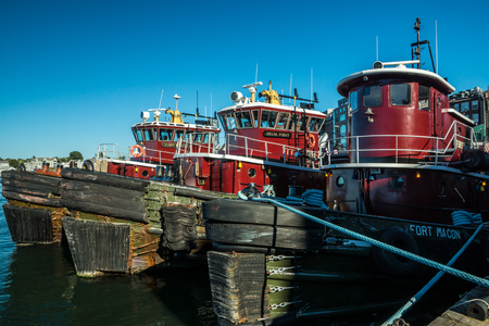 Portsmouth, Maine, USA - October 6, 2015: The fleet of famous Moran tugboats stand shipshape and ready under blue skies as a hurricane approaches.のeditorial素材