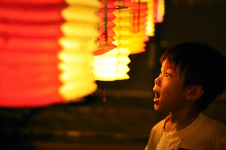 Asian Chinese kid admiring roll of tanglung. の素材