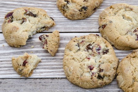 Chocolate cookies on a wooden table. White chocolate chip with berries cookies shot on a wooden plank background, closeup.の写真素材