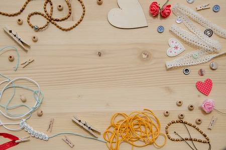 Elements for handicraft and decorative items for handmade like wooden beads, heart, buttons,decorative ribbons, braided bracelet ,rope,clips, wooden hearts, clothespins, buttons and thread. Flat layの写真素材