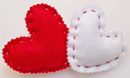 A red and a white heart together on a white backgroundの写真素材