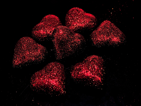 Shiny red faded hearts on a black backgroundの写真素材