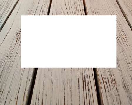 A gray wooden background with a blank white box that text can be added to at the top of the shotの写真素材