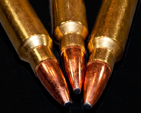 Three rifle bullets together on a black backgroundの写真素材