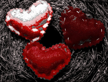 A abstract shot of three semi red hearts on a dark mossy backgroundの写真素材