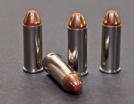Four 44spl bullets with red tips on a gray background