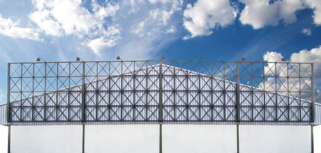 green steel blank billboard frame on facade factory under blue sky