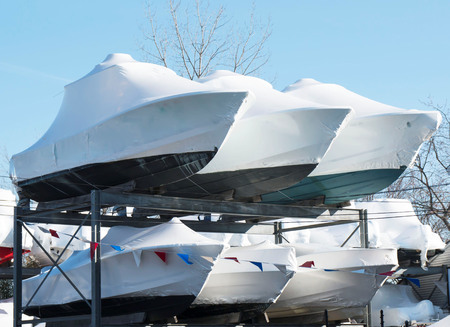 Boats stacked and stored on racks in the winterの写真素材