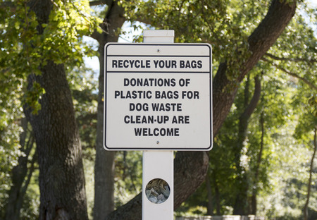 A sign in a dog walking park to donate plastic bags for waste clean-up.の写真素材