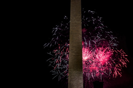 Red fireworks light the sky on the fourth of July at the Washington Monument in Washington D.C.の写真素材