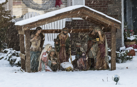 A nativity scene set up ona lawn to celebrate Chrstmas is getting covered in snow as a early December storm arrives.の写真素材