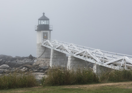 The Marshall Point Lighthouse has its light on during a very foggy summer morning.の写真素材