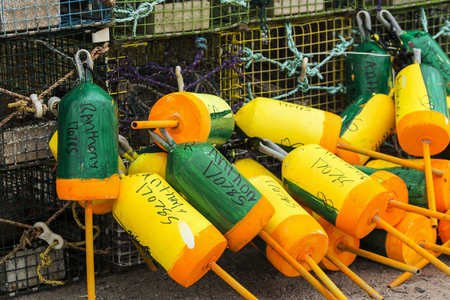 Vinalaven, Maine, USA - 5 August 2017: Close-up of marked buoys attached to lobster traps stacked up on a dock in Maine.のeditorial素材