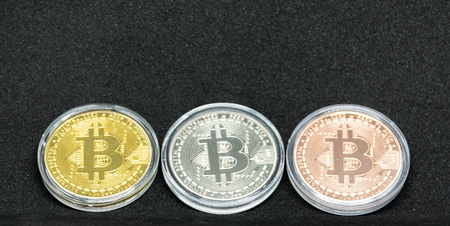 Gold, silver and bronze bitcoin coins in a protective case.の写真素材