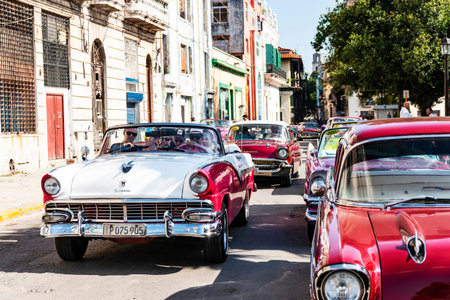 Havana, Cuba - 25 July 2018: Vintage 50's and 60's cars driving tourists around and parked on a...