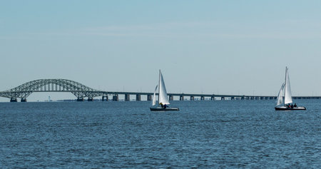 Small sailbots enjoing a beautiful day in the great south bay with the Robert Mosses bridge in the background,の写真素材