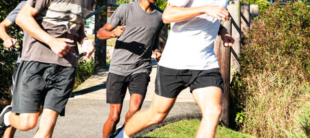 Group of high school boys running together turning left off of a wood bridge at a local park...