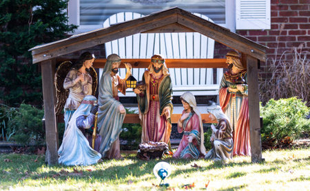 A christmas nativity decortation on a front lawn celebrating the holiday in daylight.