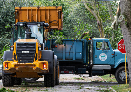 Babylon, New York, USA - 23 August 2019: Babylon Village trucks clearing a road full of trees after...