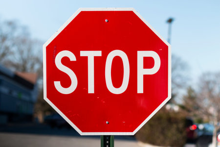 A close up of a red stop sign outside in a parking lot.