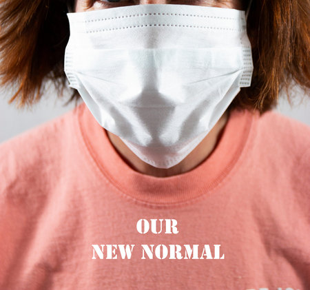 Face mask covering face on a women whos shirt reads our new normal because of the coronavirus...