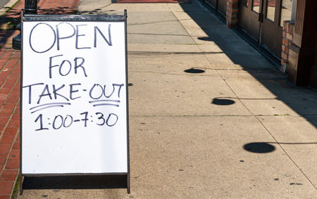 A sign on a sidewalk of restaurant is open for take out food only due to the coronavirus COVID-19...