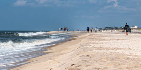 Ocean Beach, New York, USA - 7 July 2019: People walking next to the Atlantic Ocean on the sand of the beach on Fire Island National sea shore.のeditorial素材