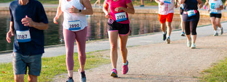 Front view of a line of runners during a 5K race at Belmont Lake State Park.の写真素材