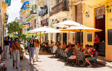 Havana, Cuba - 26 July 2018: A street with tables set up under umbrellas outside restaurants for tourists and locals to enjoy their day.のeditorial素材