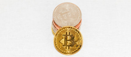 Horizontal view of a pile of bitcoin coins and one gold coin facing forward with copy space.