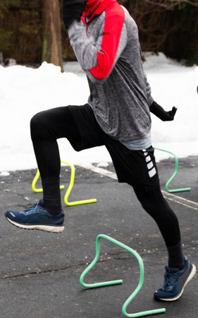 Track and field practice moved to a parking lot bacause of a snow storm with a runner running over...