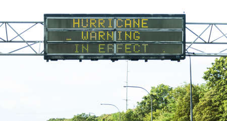 A sign hanging above a long island hiway warning of an impending hurricane.の写真素材