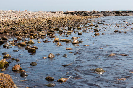 Rocky beach and rock jetty extending out into Narragansett Bay in Point Judith Rhode Island.