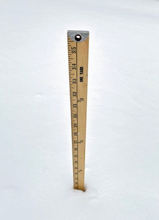 A wooden yardstick placed in the snow measuring nineteen inches of snowfall.の写真素材
