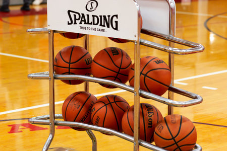 West Islip, New York, USA - 8 February 2022: Many basketballs on a rack at half court for both teams...