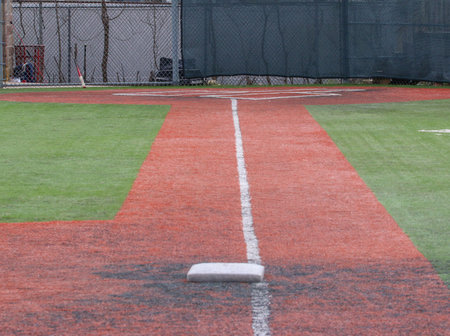 Looking down the white foul line from third base to the batter box of a turf baseball field