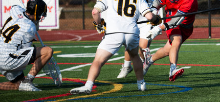 Close up of a high school boy lacrosse goalie making a save during a game.の写真素材